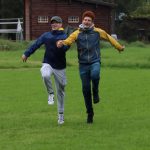To glade ungdommer som kommer løpende hånd i hånd