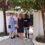 Fire personer foran porten til Gambia Care