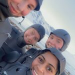 Selfie av fire elever fra Vefsn Folkehøgskole Toppen iført surfedrakter.