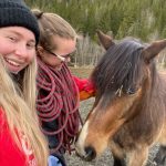 To elever ved Vefsn Folkehøgskole Toppen står og koser med en hest.