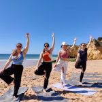 Fire elver fra Vefsn Folkehøgskole Toppen gjør yoga på stranda i Portugal.