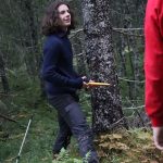 Elev fra Vefsn Folkehøgskole Toppen står ute i skogen og holder en frisbee.